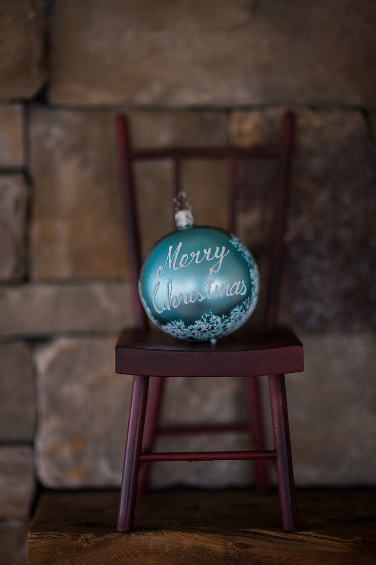 Turquoise Christmas bauble on miniature chair