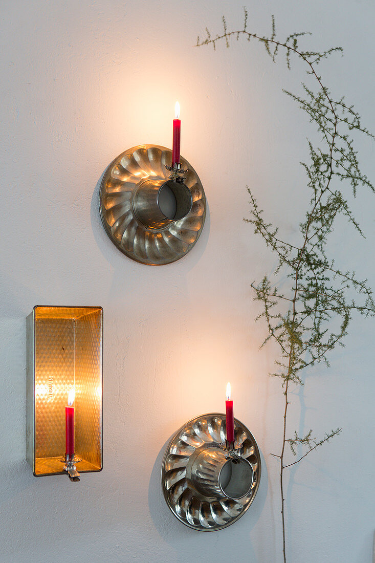 Candle sconces made from old cake tins and candles on candle clips