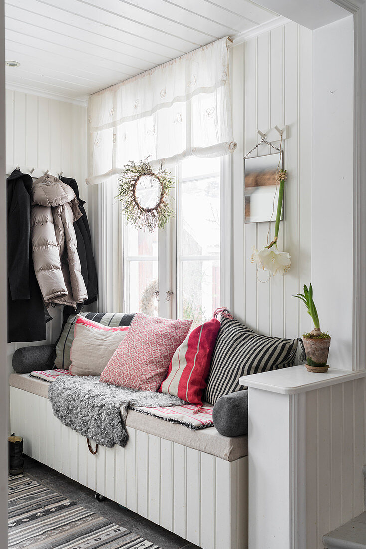 Cushions and sheepskin on bench in hallway