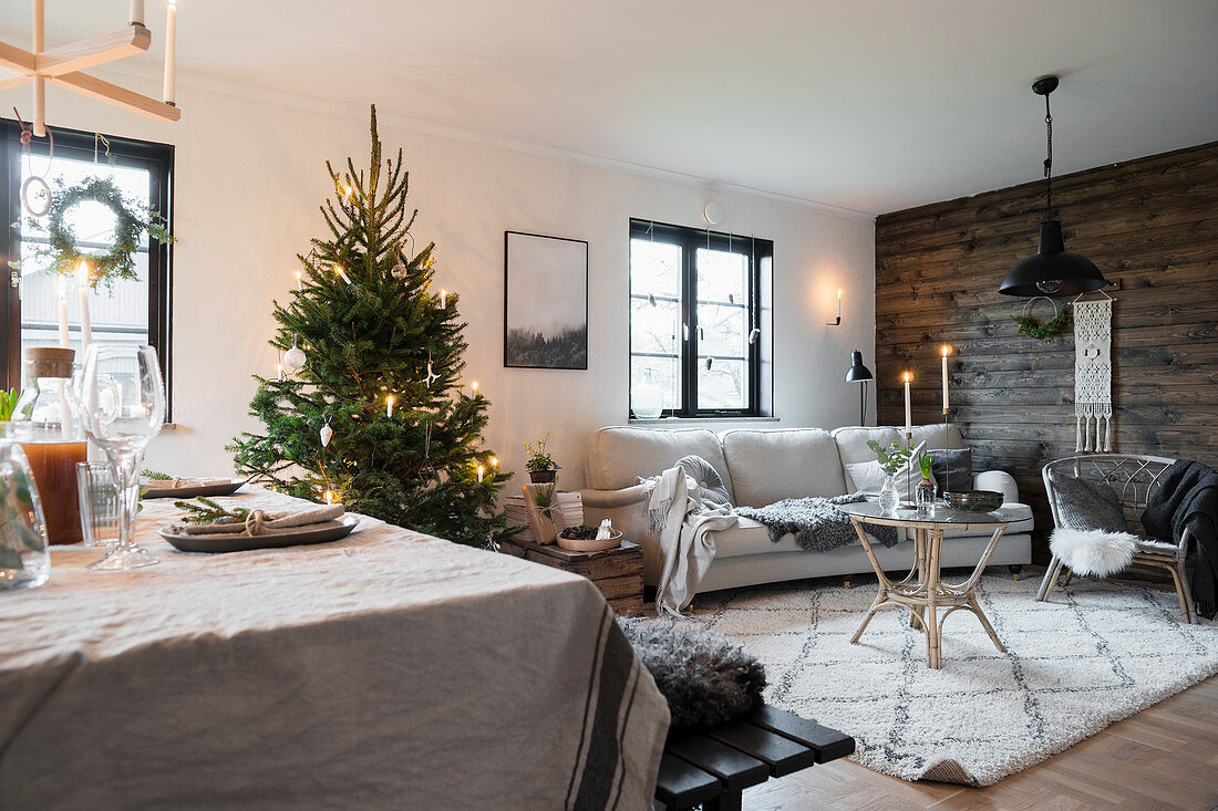 Gemütlicher Wohnraum mit Weihnachtsbaum und Bretterwand