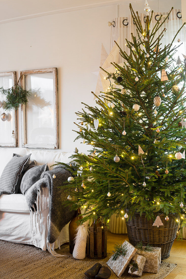 Simply decorated Christmas tree in basket in living room