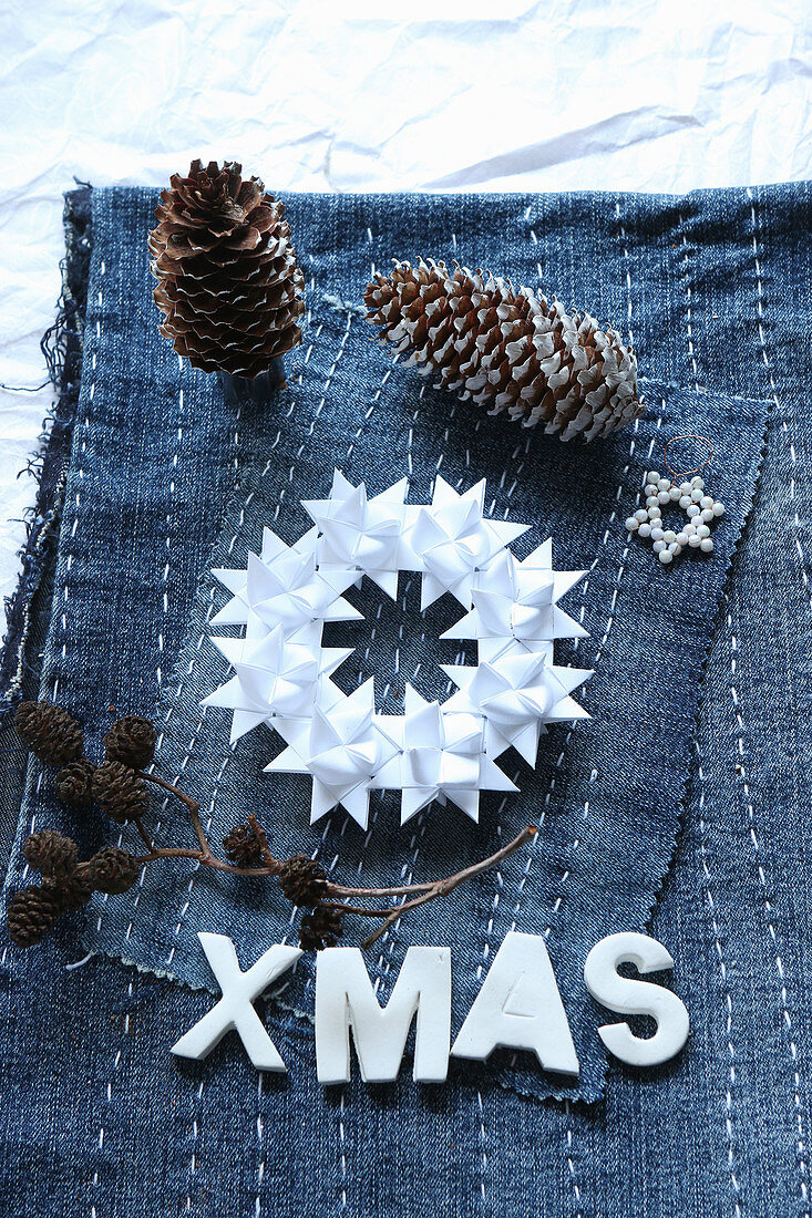 Wreath of folded paper stars on denim embroidered with lines