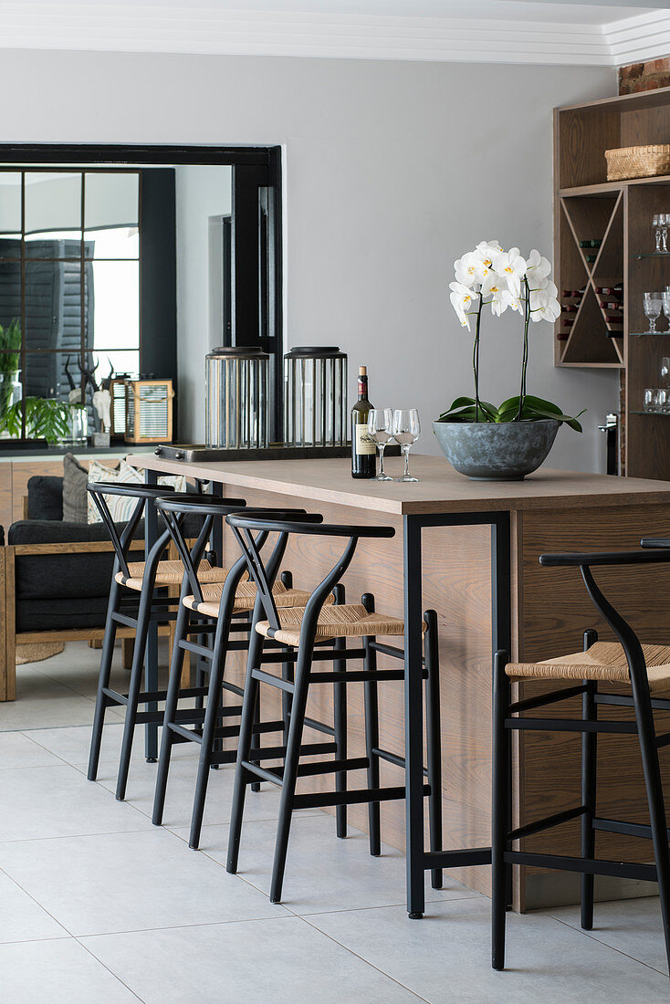 Tall black stools at wooden kitchen counter