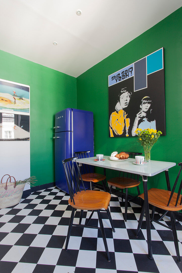 Retro-style kitchen-dining room with green walls and chequered floor
