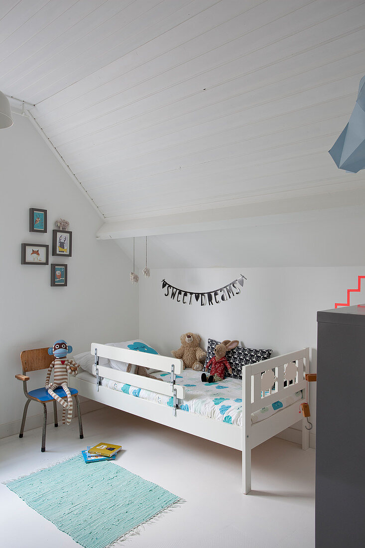 White, child's bed in attic nursery