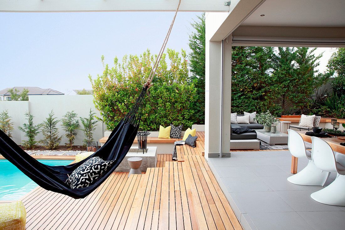Hammock between swimming pool and roofed terrace
