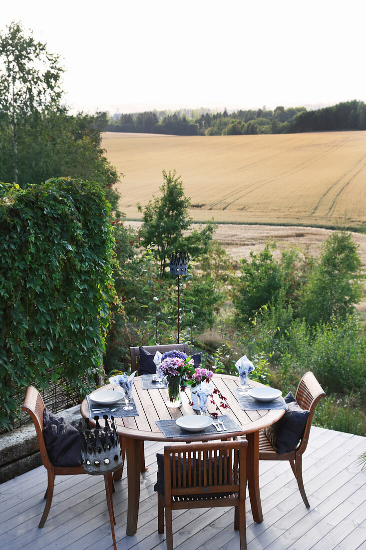 Set table on terrace with view of woods and fields