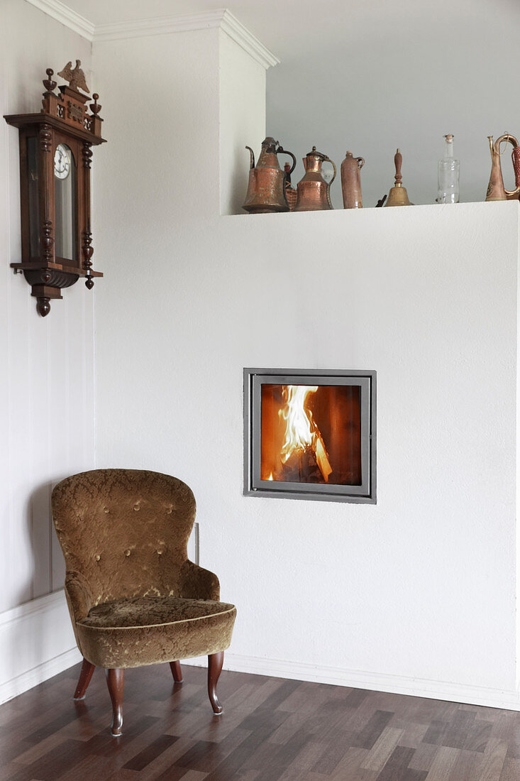Old armchair next to fireplace integrated into wall