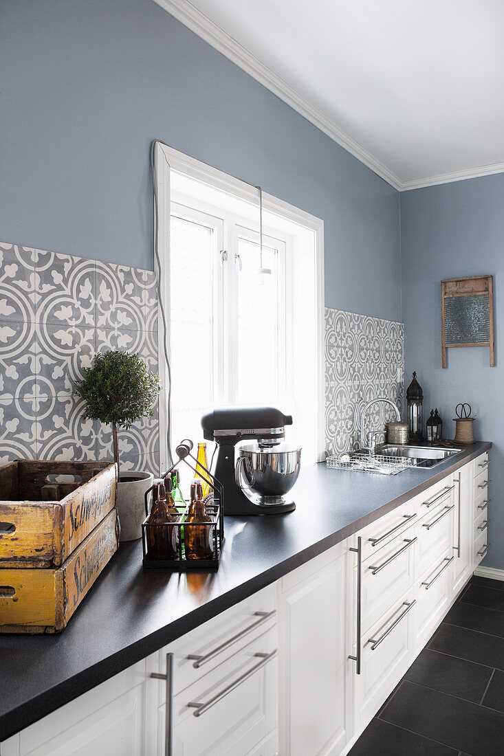 Moderne Landhausküche mit Musterfliesen und blauer Wand