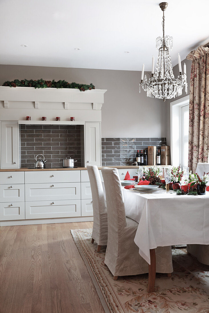 Festively set Christmas table in rustic kitchen-dining room