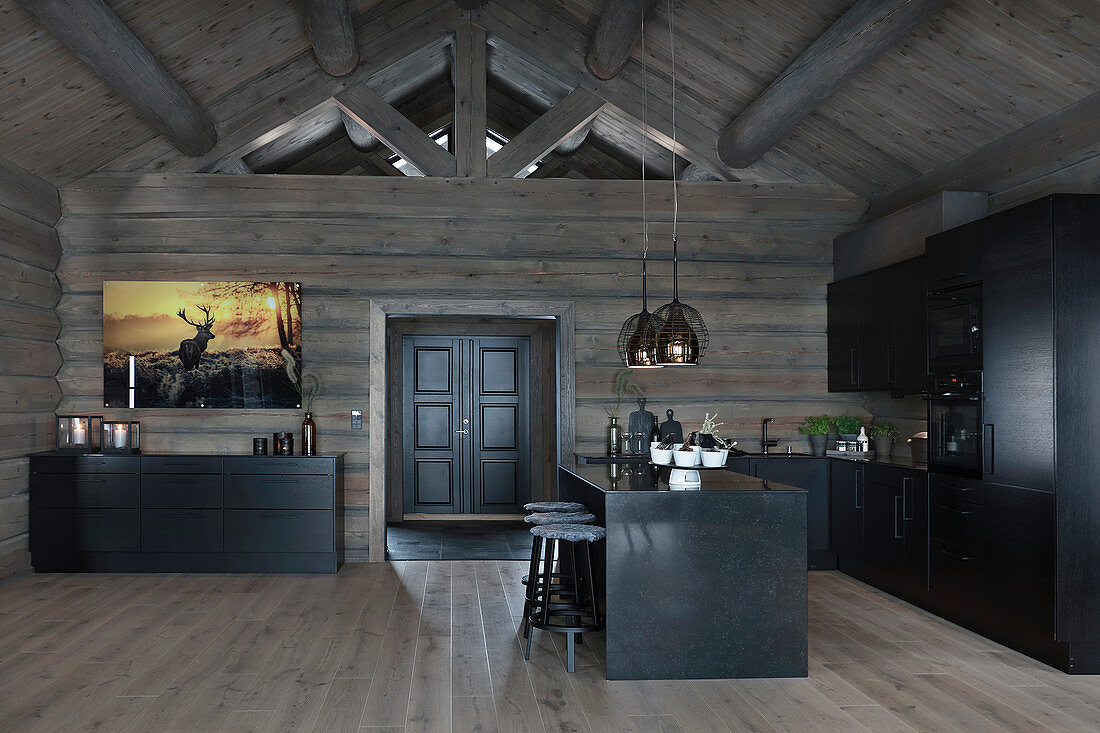 Modernes Blockhaus mit dunklem Holz und schwarzer Küche
