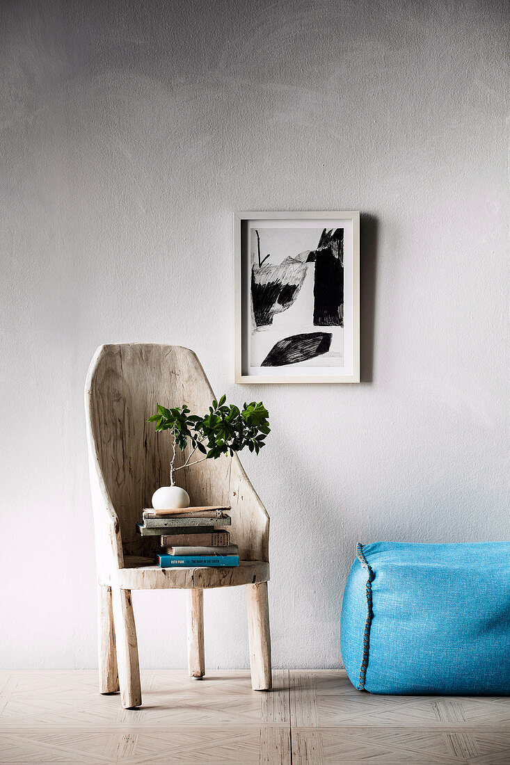 Rustikaler Holzstuhl mit Bücherstapel und Bonsai