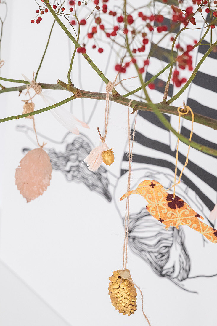 Zweig mit goldenen Zapfen und Papiervogel dekoriert