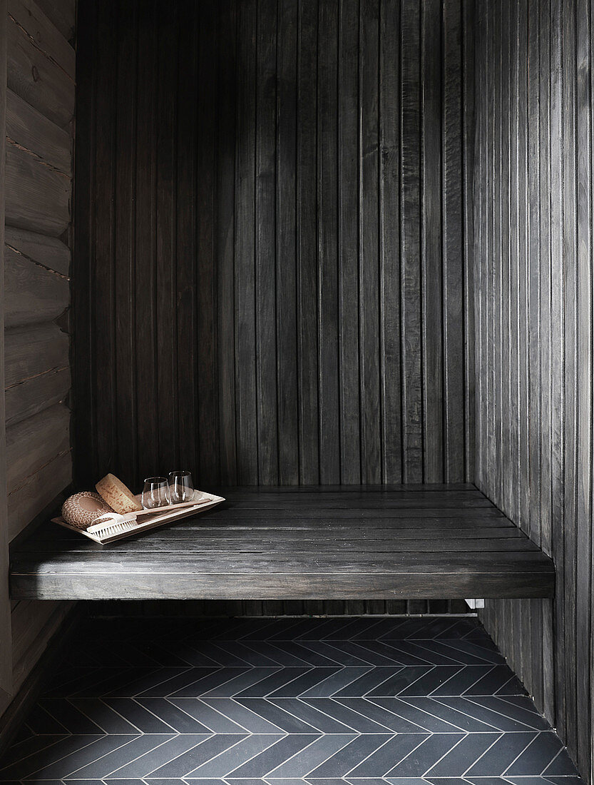 Sauna utensils on bench in niche in log cabin