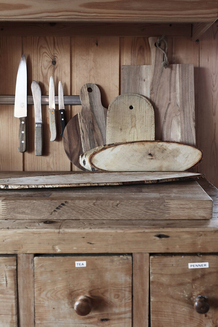 Messer und Holzbretter über Küchenunterschrank