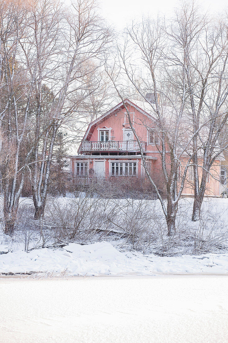 Red wooden house in snowy landscape