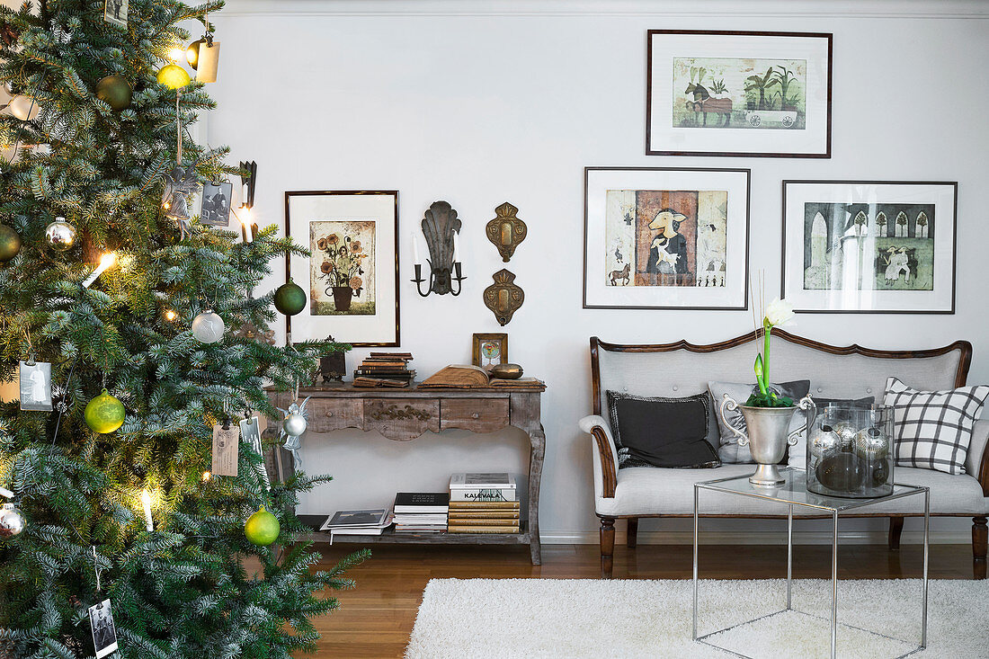 Geschmückter Tannenbaum im Wohnzimmer mit Polsterbank und Bildergalerie