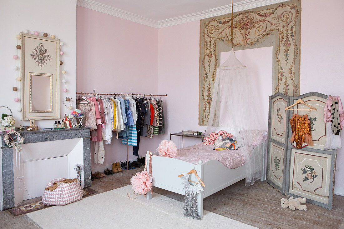 Romantisches Mädchenzimmer mit weißem Bett, Paravent und Kleiderstang