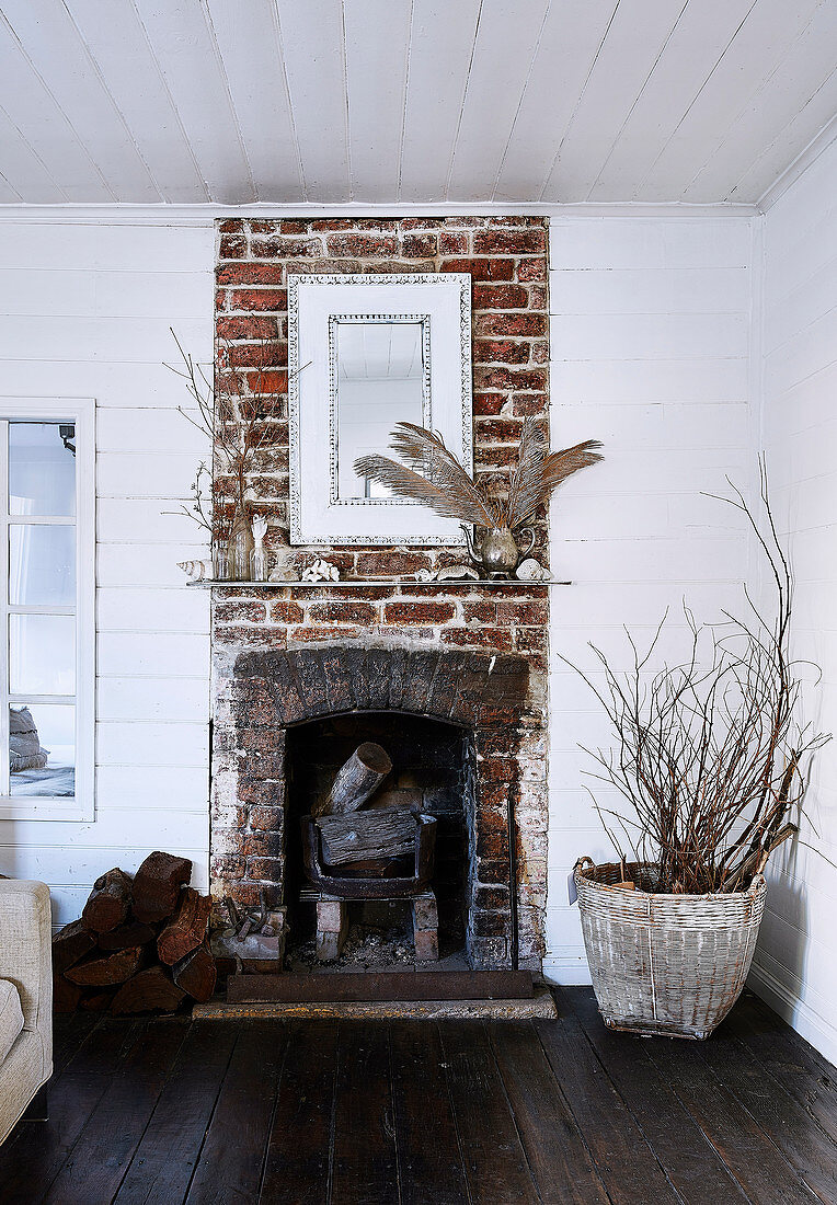 Rustic brick fireplace in the living room with white painted wooden walls