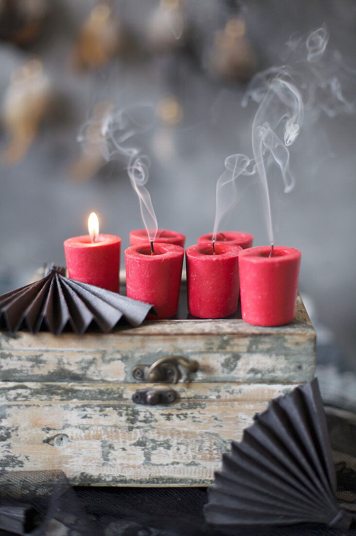 Brennende und erloschene Kerzen auf alter Holzkiste