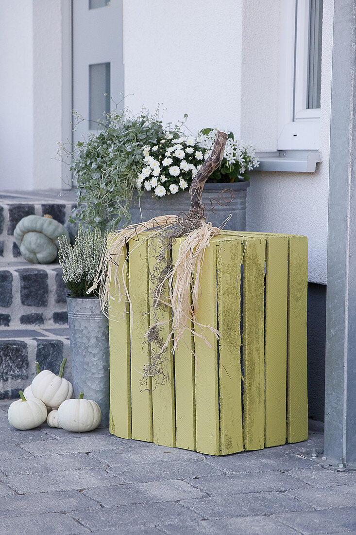 Autumnal arrangement with wooden crate made into pumpkin