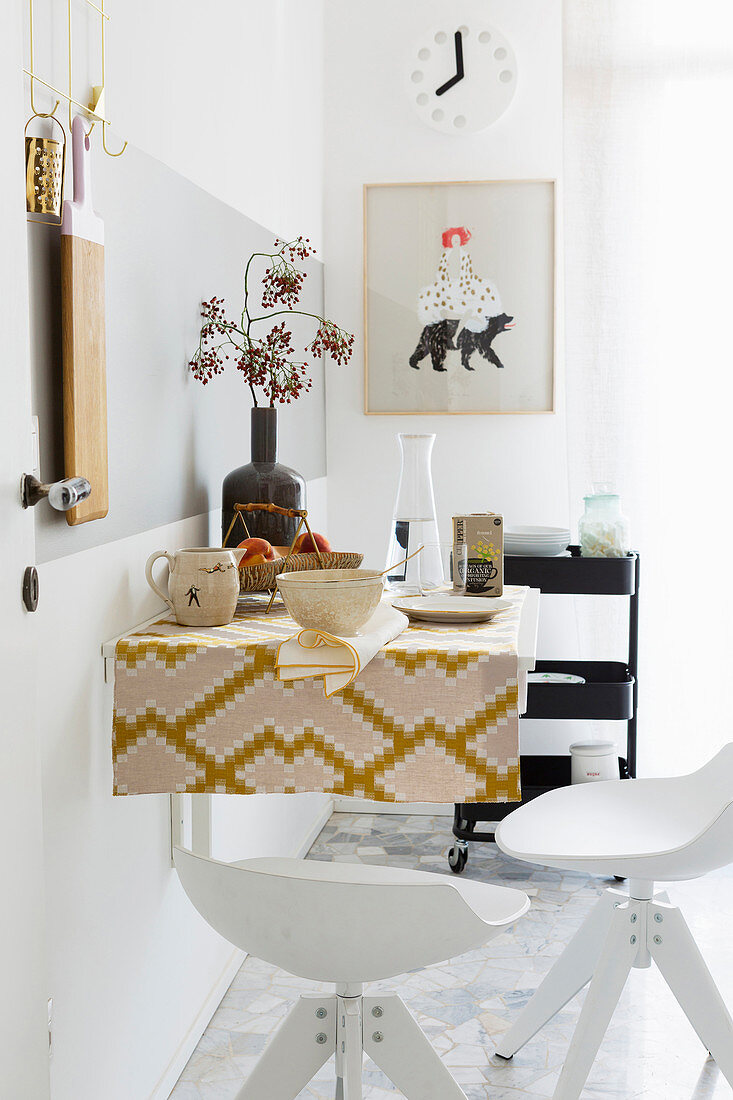 Wandtisch mit Retro Tischdecke und Barhockern in der Küche