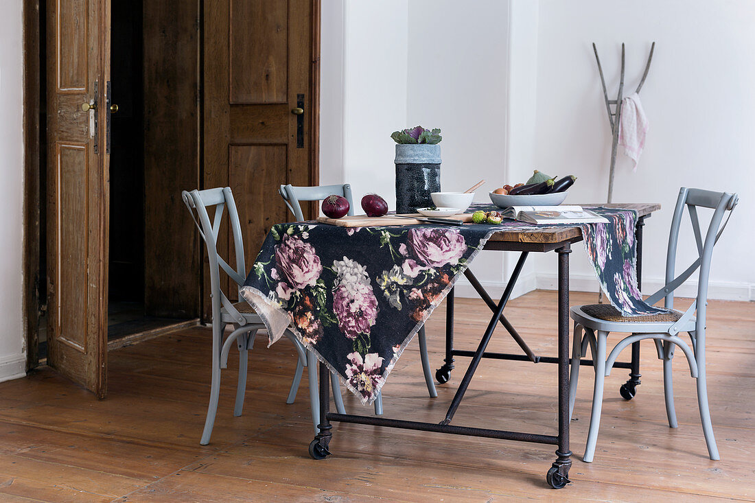 Floral fabric on rustic table and grey bistro chairs