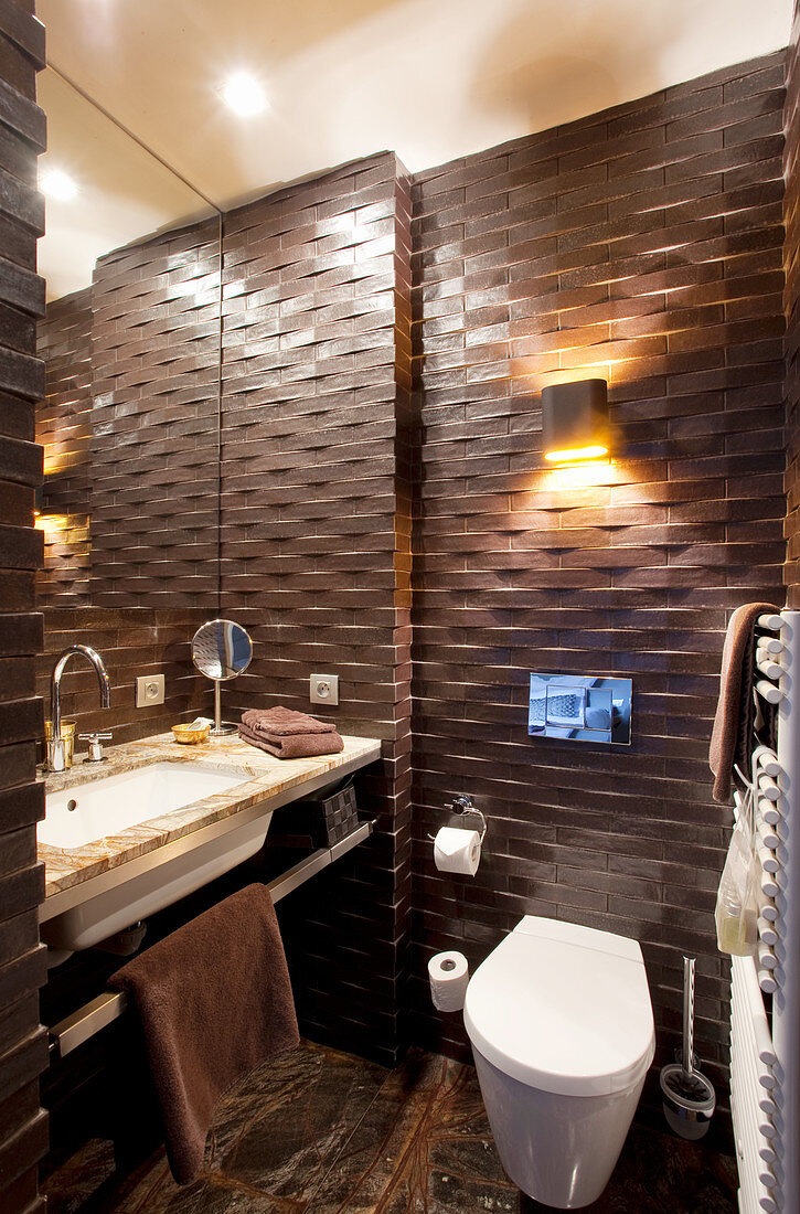 Dark structured wall tiles in small bathroom