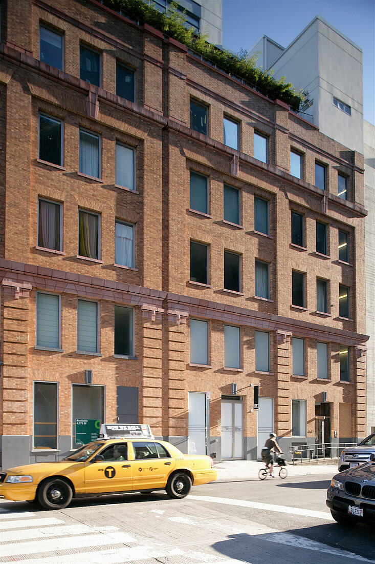 Yellow taxi outside typical American brick façade