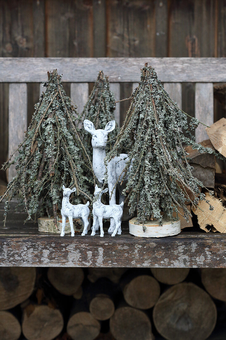 Christmas tree ornaments made from branches covered in lichen on bench