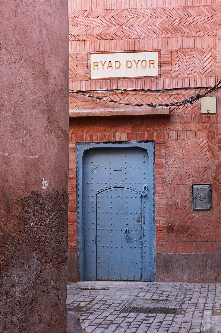 Ziegelfassade mit blauem Tor vom Hotel Ryad Dyor (Marrakesch, Marokko)