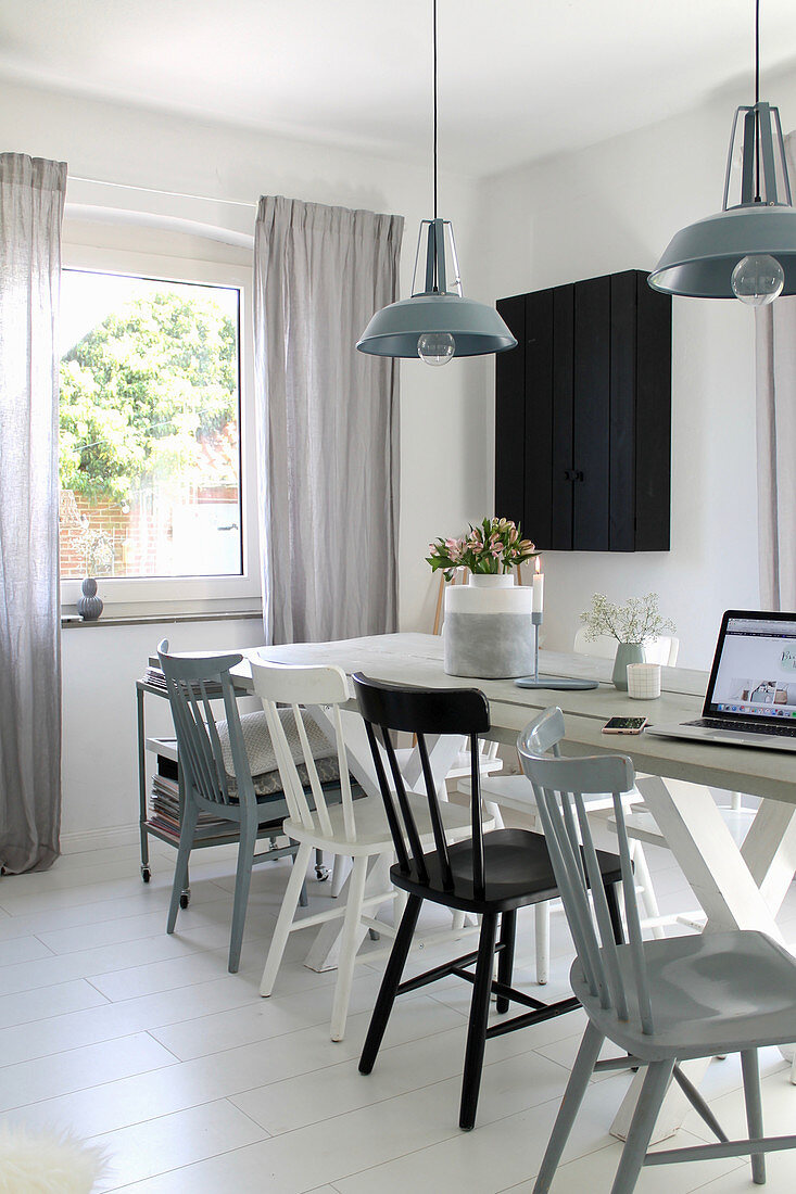 White wooden table and wooden chairs in bright dining room