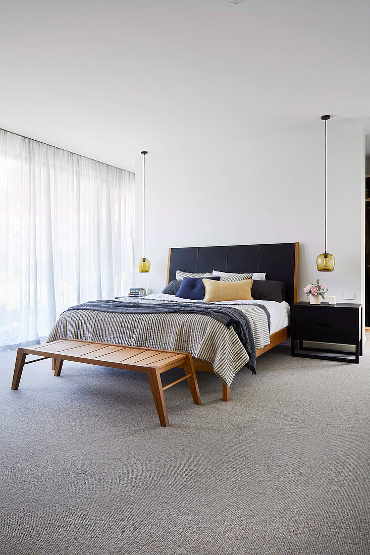 Schlichtes Schlafzimmer in gedeckten Farben mit Teppichboden