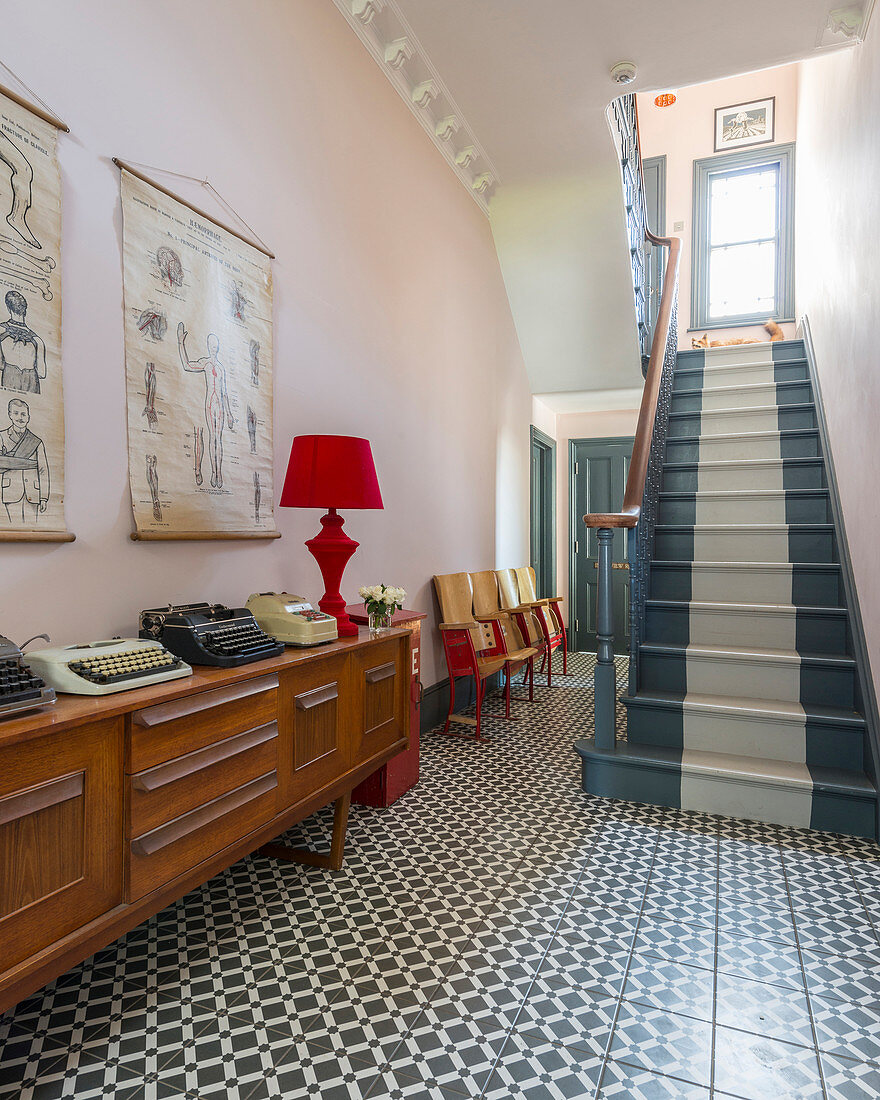 Patterned floor and striped staircase in entrance hall of period building