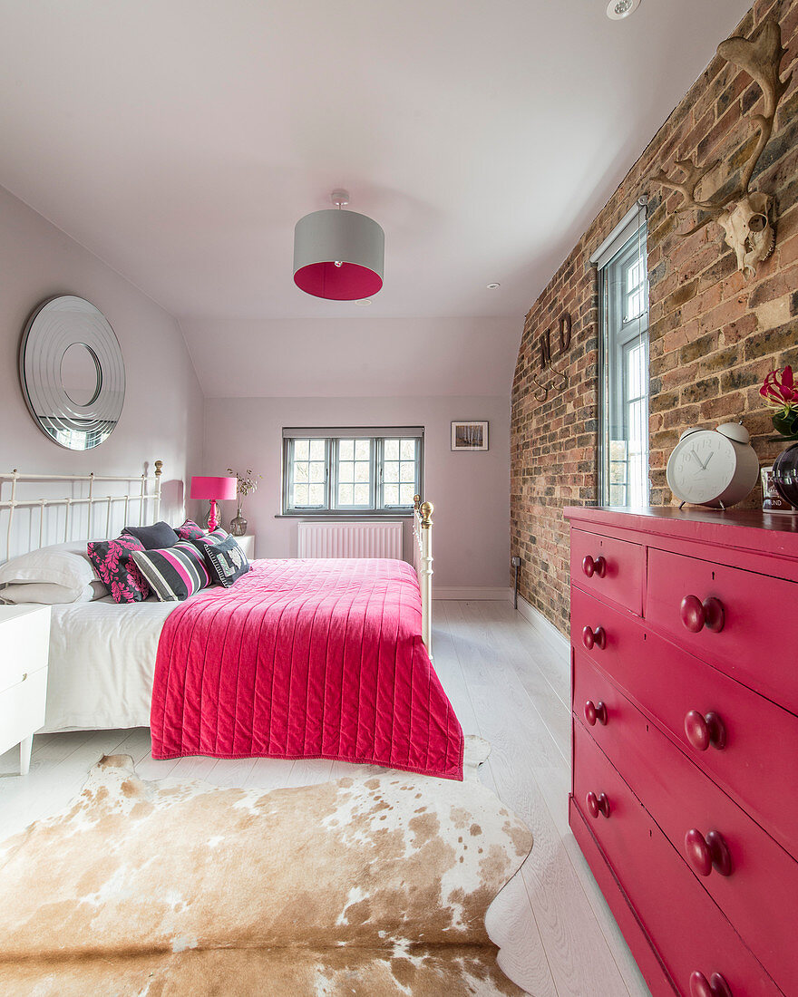 Schlafzimmer mit Backsteinwand und Akzenten in Pink