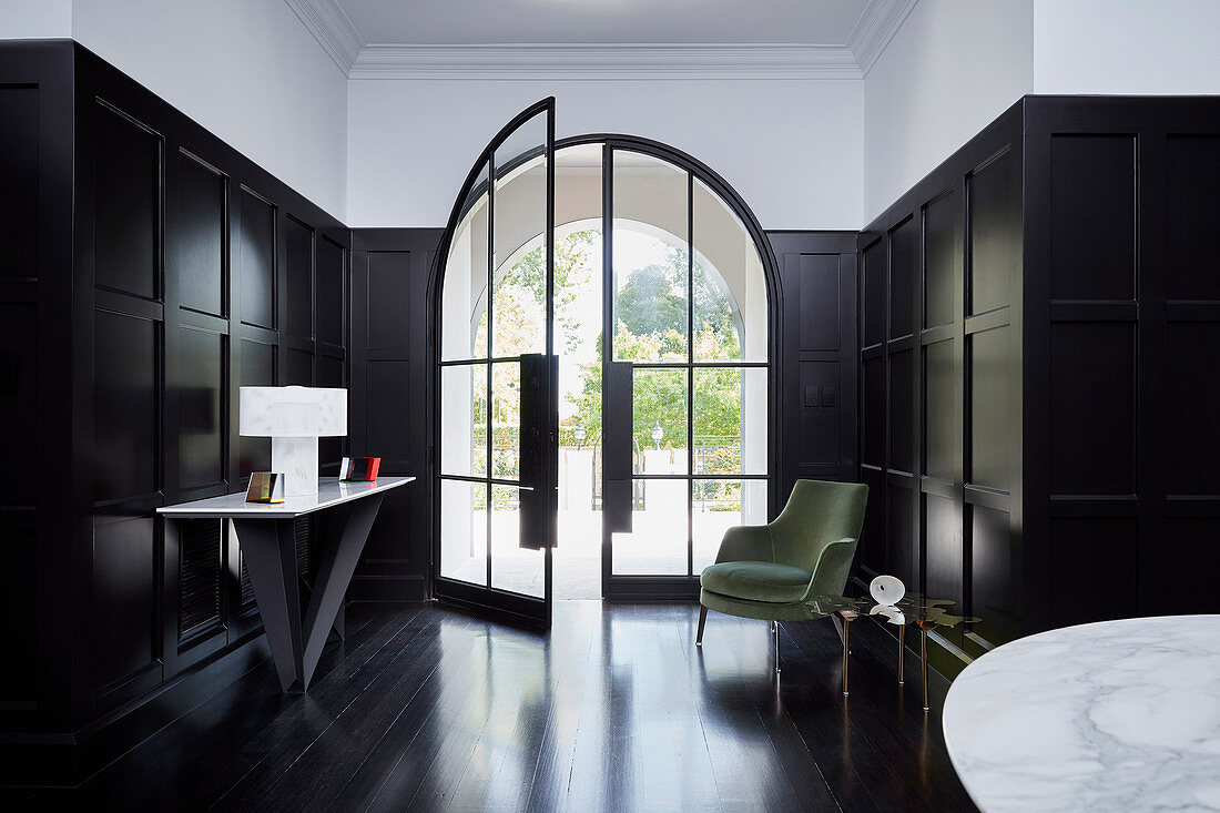 Elegante Eingangshalle mit Glastür, Kassettenverkledung und dunklem Holzboden