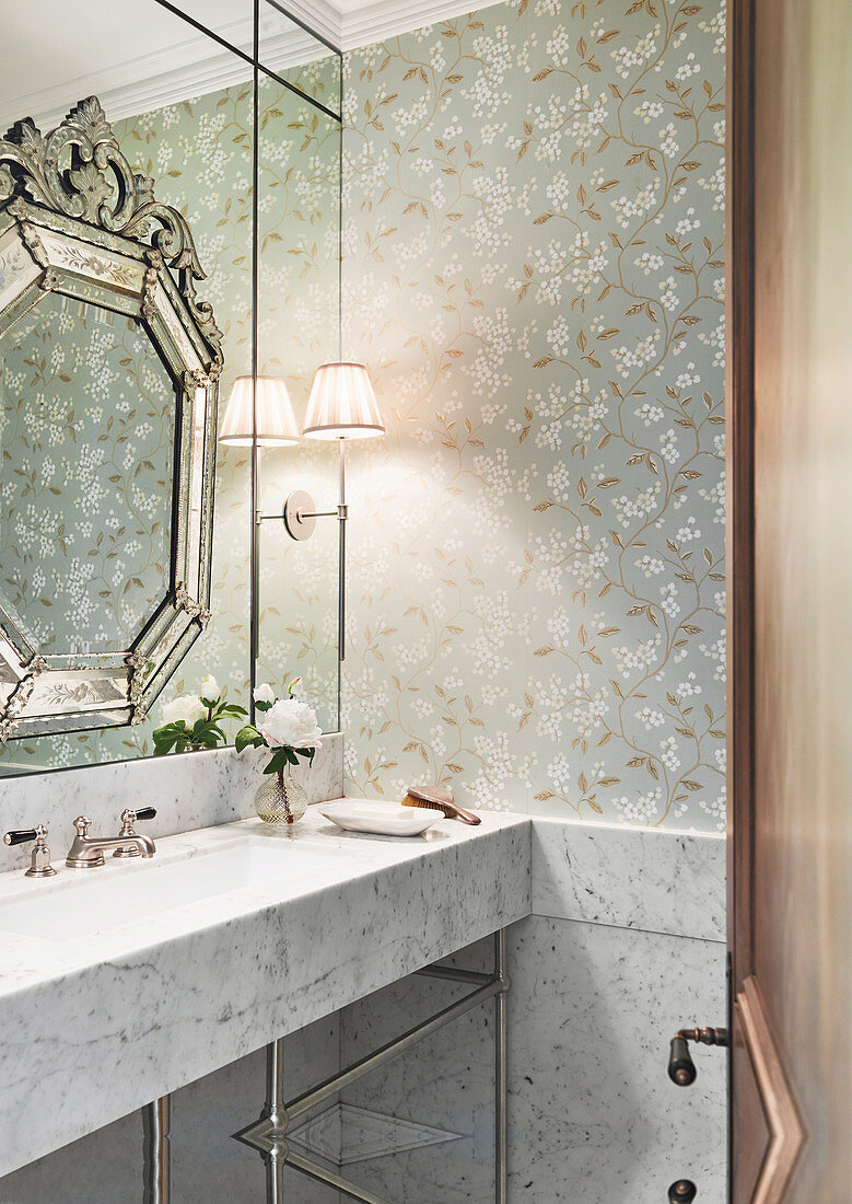 Marble vanity and wall mirror in the bathroom with wallpaper