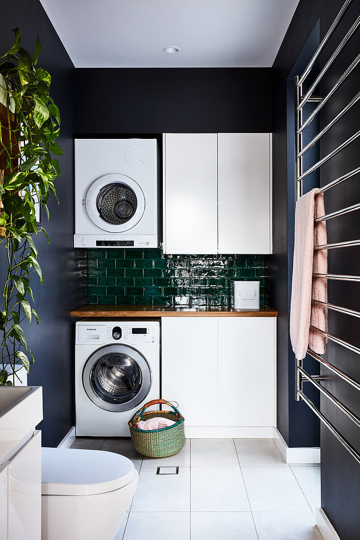 Washing machine and tumble dryer against tiled wall in utility room