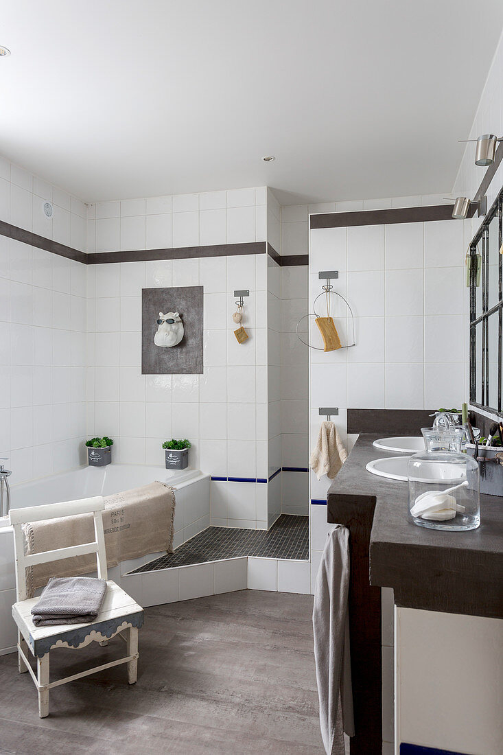 Waschtisch mit zwei Waschbecken und Badewanne in weiß gefliestem Badezimmer