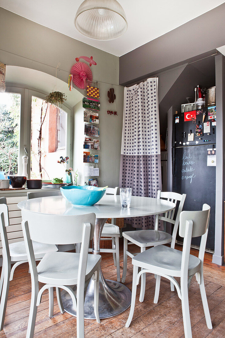 Runder Tisch mit Holzstühlen Kühlschrank mit Tafellack in Niesche in einer Küche