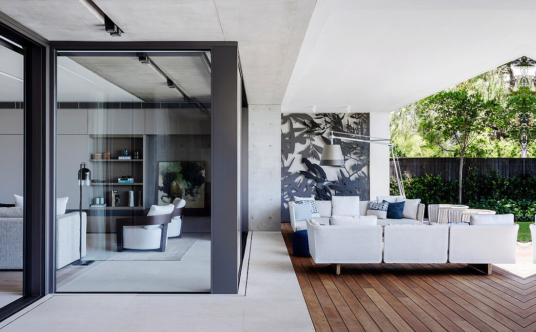 Elegante Outdoor-Lounge, Blick durch Verglasung ins Wohnzimmer