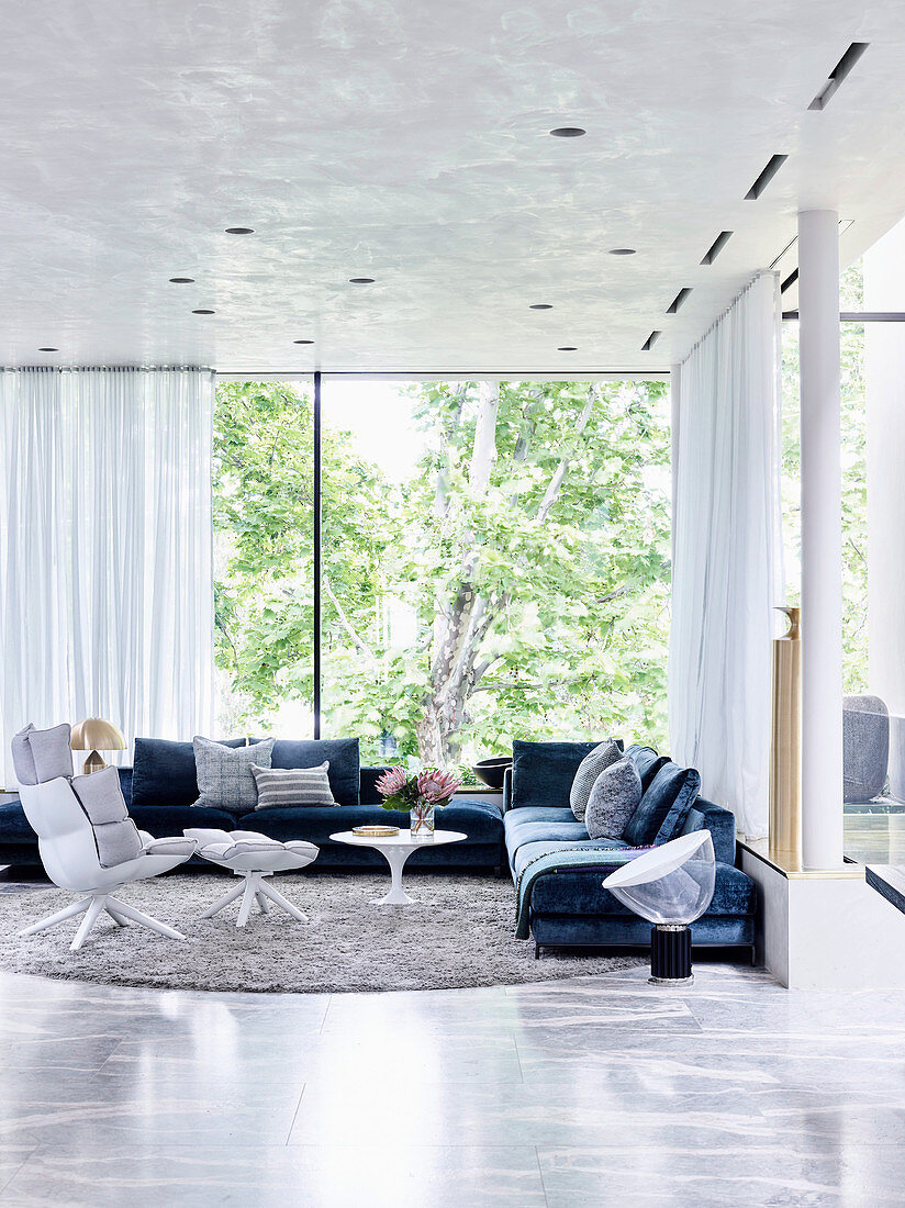Elegantes Wohnzimmer mit Polstergarnitur und Glasfront