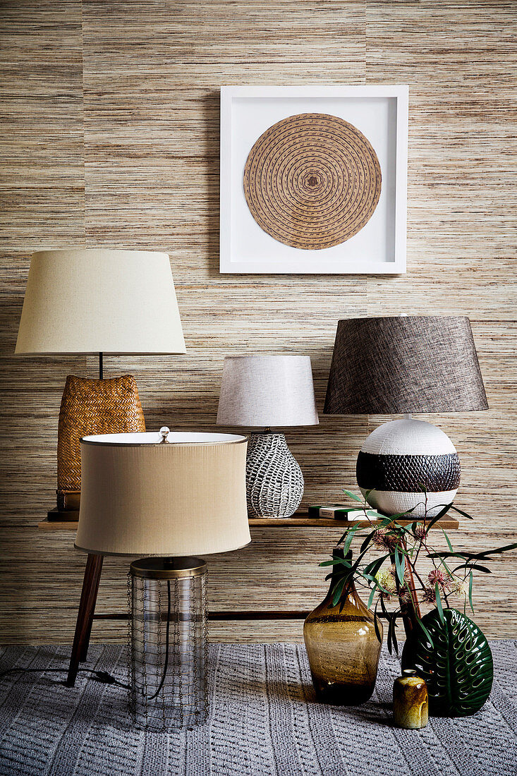Various table lamps in shades of brown against a wallpaper