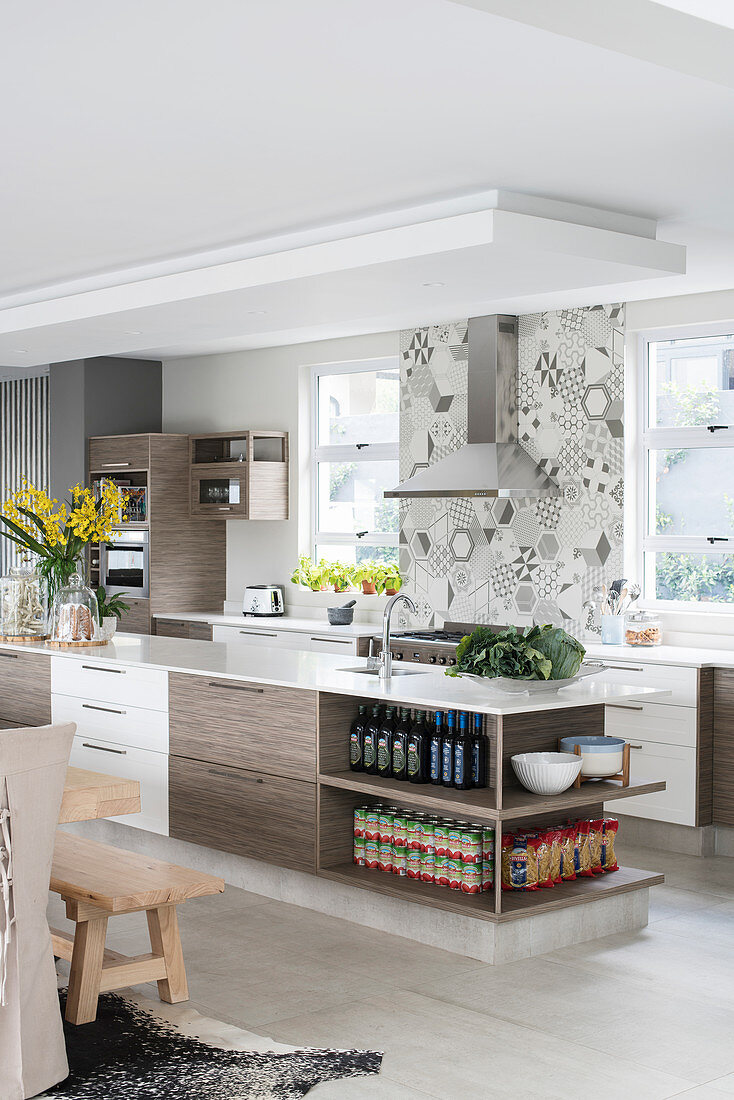 Groceries on shelves of island counter in modern, open-plan kitchen