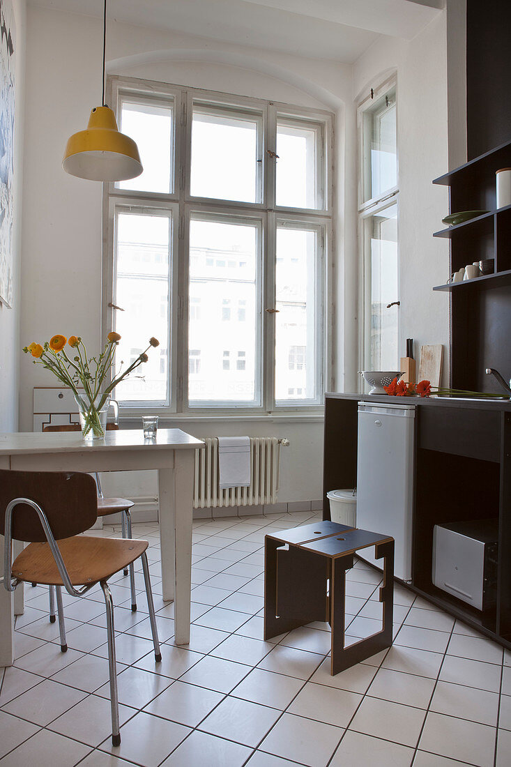 Schwarz-weiße Küche mit Tisch und zwei Stühlen in Altbauwohnung