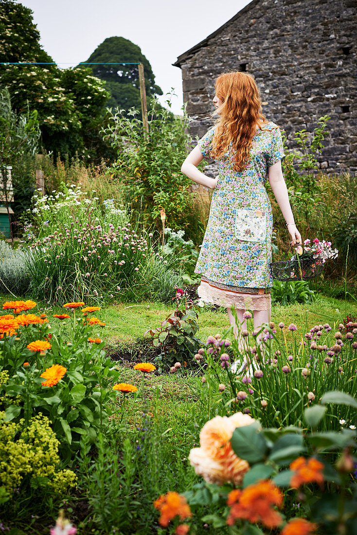 Red-haired woman wearing floral dress in garden