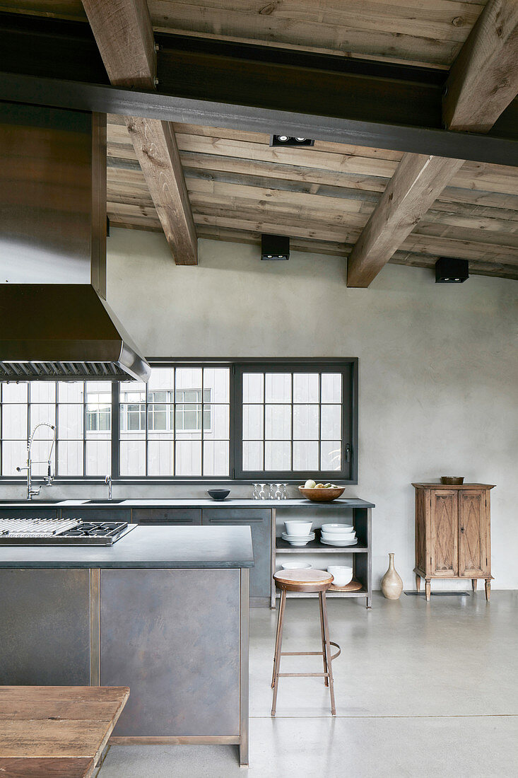 Open-plan, industrial-style kitchen-dining area with high ceiling
