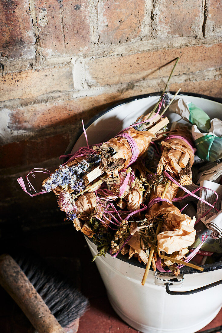 Bundles of kindling and herbs tied with raffia in bucket