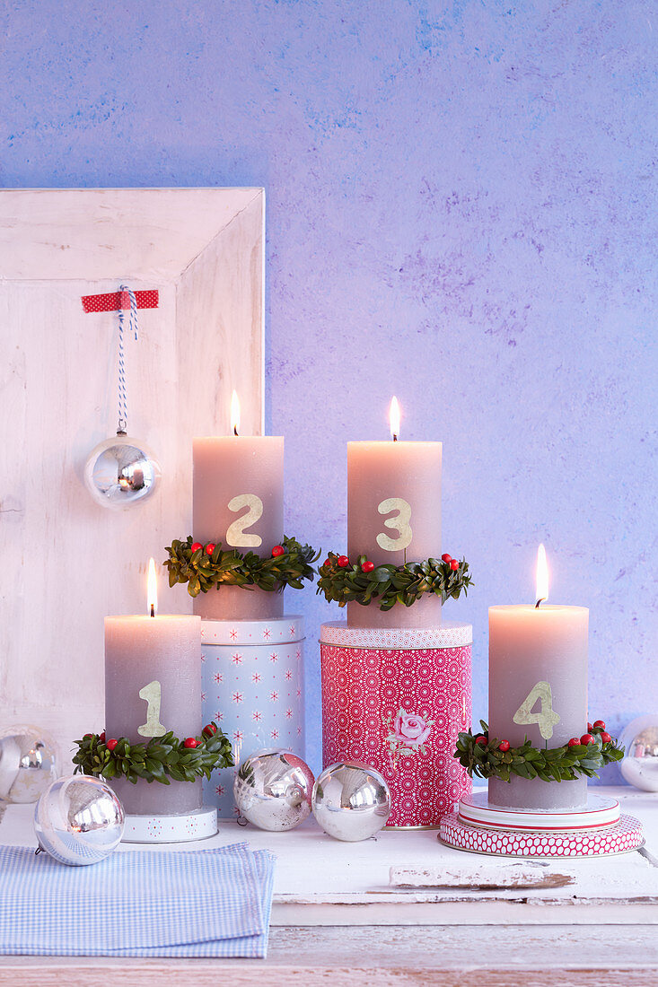 Advent candles decorated with number and box wreaths