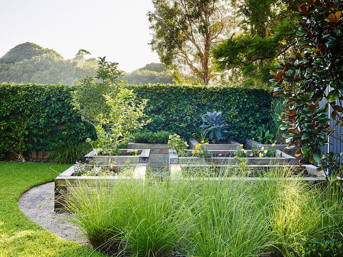 Hochbeete mit Holzeinfassung in elegant angelegtem Garten